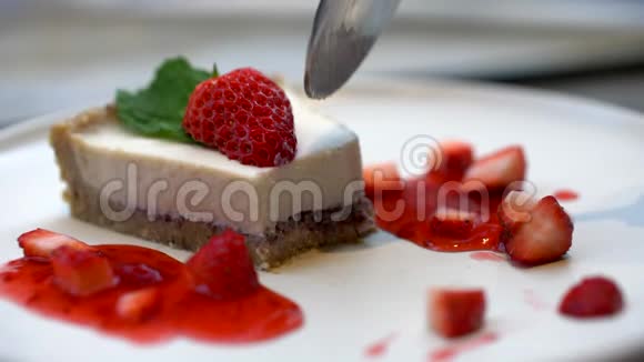 勺子拿一片美味的草莓芝士蛋糕Bokeh慢动作4k视频的预览图