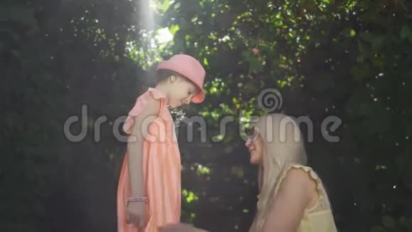 母亲和女儿一起在夏天的花园或公园里度过女孩吻妈妈家庭幸福妇女与妇女视频的预览图