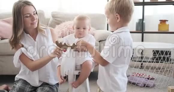 妈妈和儿子带着小女孩在家摇鹿视频的预览图