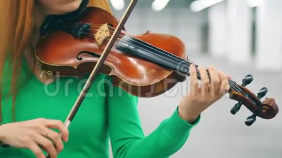 一个女人独自表演时拿着木制小提琴视频的预览图