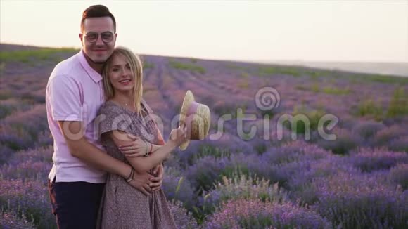 年轻夫妇站在盛开的薰衣草花田的肖像视频的预览图