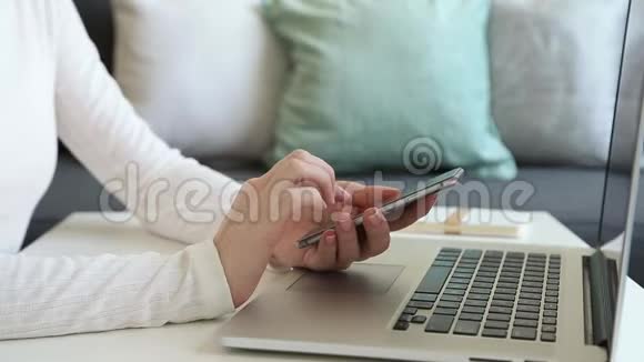 女性手浏览智能手机自由职业者在家工作视频的预览图