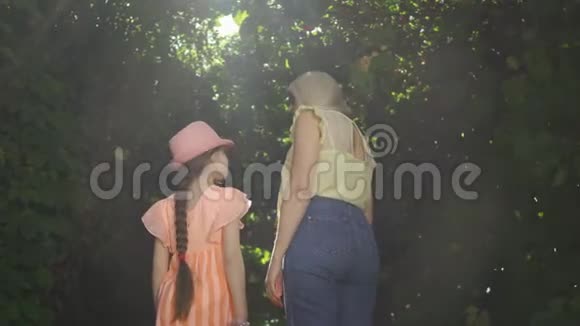 后景金发母亲与女儿在夏园或公园牵手散步家庭幸福连接视频的预览图
