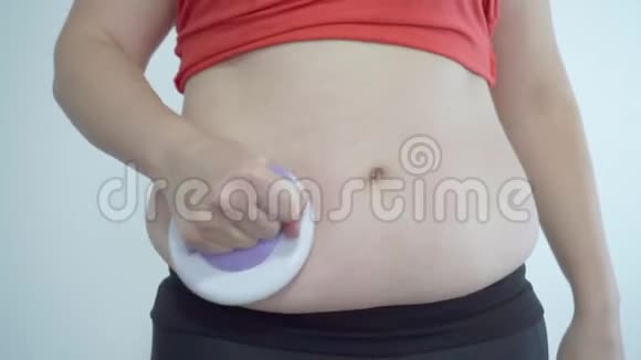 胖女孩做腹部按摩以摆脱多余的体重含有脂肪的按摩器视频的预览图