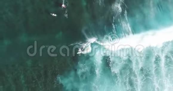 自上而下的空中跟踪拍摄技术娴熟的男性冲浪者在晴朗的蓝色天气里乘着巨浪在海上捕捉海浪视频的预览图