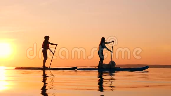 日落湖妈妈和儿子骑着桨板视频的预览图