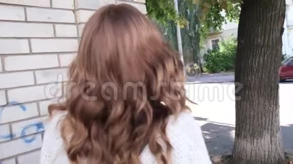 一个棕色头发的女孩在街角偷看视频的预览图