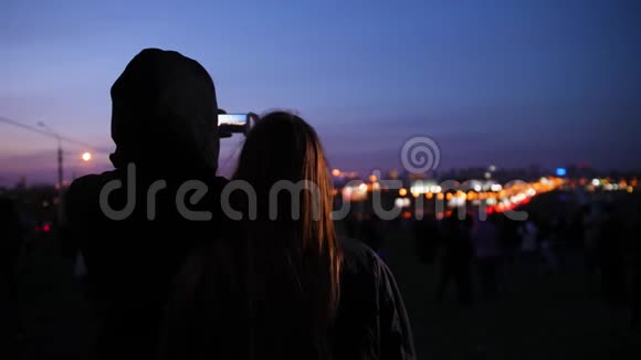穿着黑色衣服的女孩和男人在电话里拍下的夜城视频的预览图