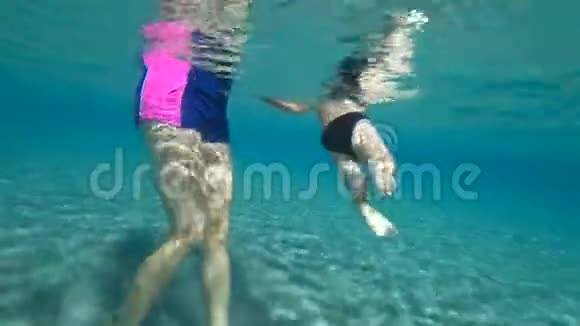妈妈抱着孩子在水里男孩试图在海里游泳男孩积极地在水里移动他的腿视频的预览图