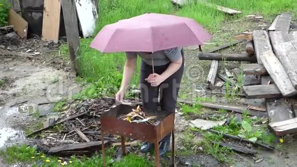 带着雨伞的女人在雨中烧烤视频的预览图