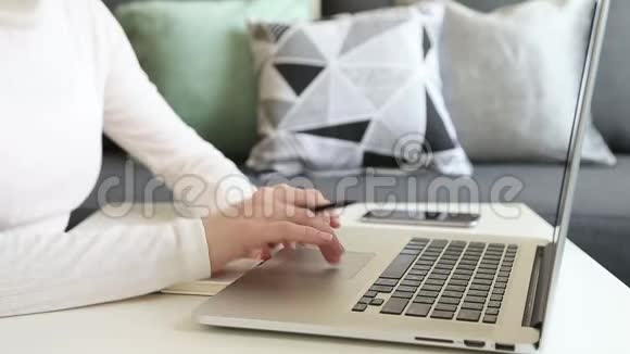 自由职业者在家里用笔记本电脑工作女性手拿铅笔视频的预览图