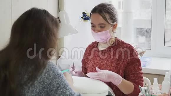 女粉指甲技师给客户做指甲的医用口罩和手套视频的预览图