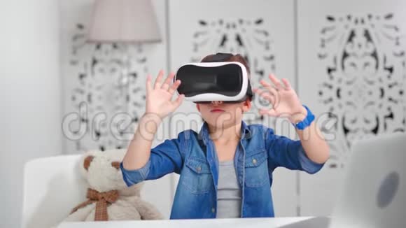 热情的儿童男孩戴着虚拟现实耳机在网络空间周围做手势视频的预览图