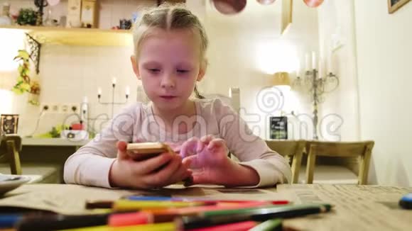 小女孩在她的智能手机上写聊天信息一个孩子在他的智能手机上玩游戏孩子用手机玩游戏视频的预览图