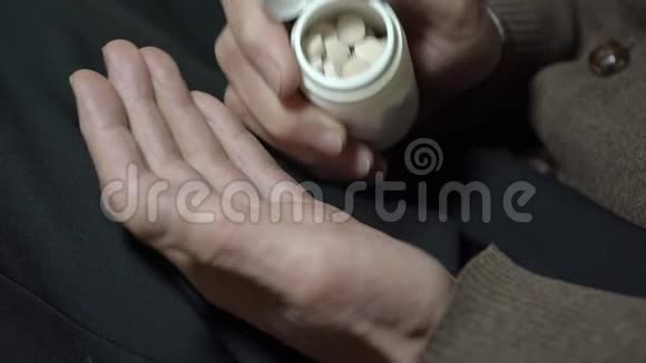 老人把白色药片从罐子特写镜头放到手掌上视频的预览图