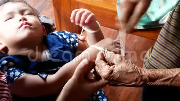 一位年迈的泰国人家中的一个婴儿手腕上绑着圣白线西罪视频的预览图