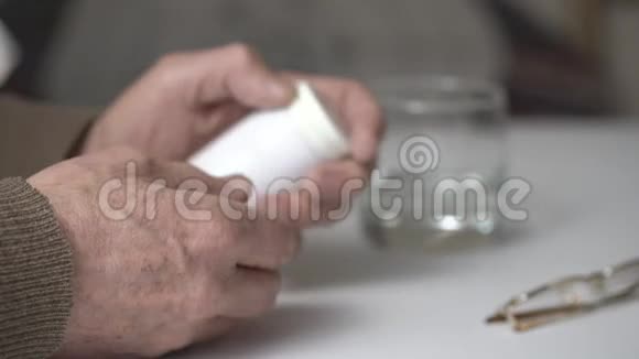 老人打开塑料瓶白色桌子上放着药丸视频的预览图