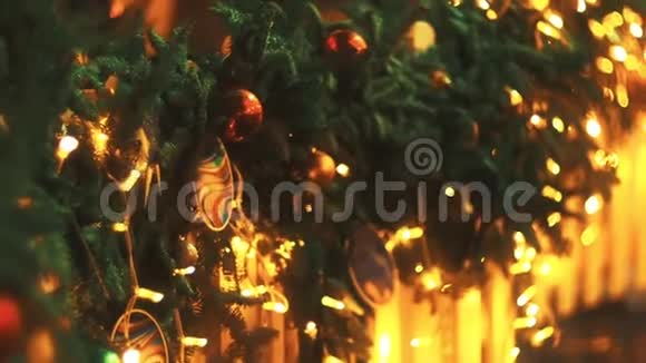 镜头从下到上移动重点放在挂在圣诞树花环上的彩色球上上面覆盖着视频的预览图
