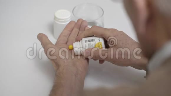 成熟的人从上面的塑料罐子里拿出黄色的药片视频的预览图