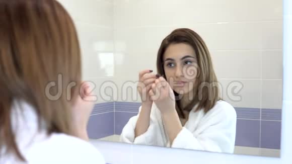 年轻女子把化妆品贴在脸上水疗棕色水凝胶贴片用于皮肤年轻化女人是视频的预览图