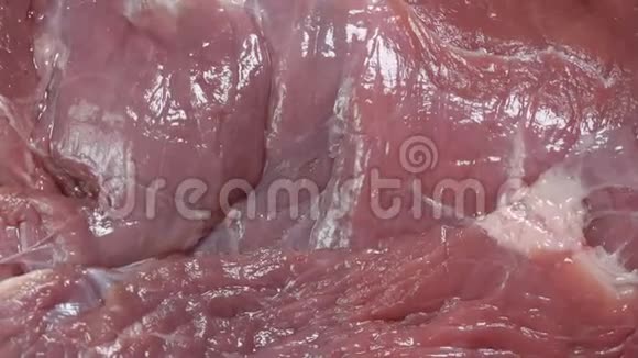 在巨大的新鲜猪肉块上的近距离观察视频的预览图