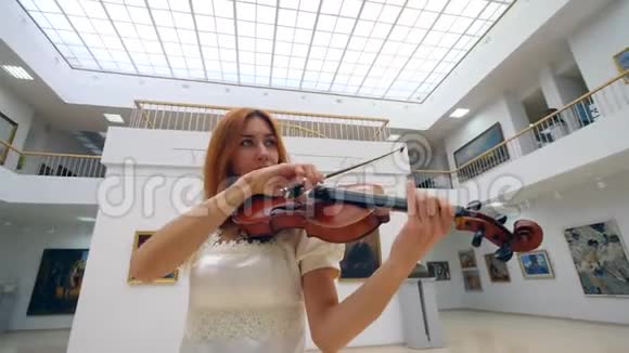 一位穿着白裙子的女音乐家正在拉小提琴视频的预览图