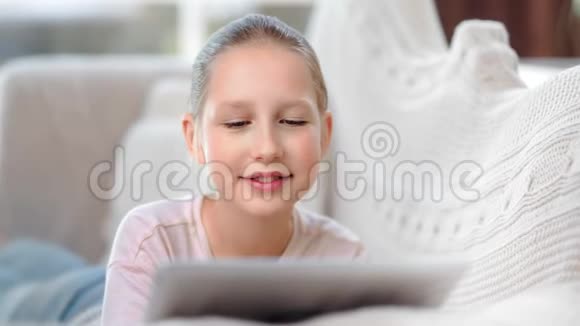 在家玩平板电脑玩得开心的时候一个小女孩用平板电脑聊天视频的预览图