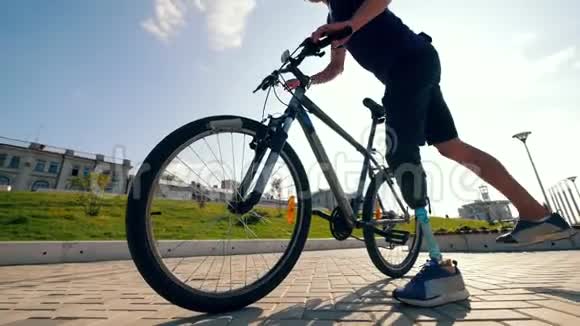 一个有仿生腿的运动员正在把自行车开走视频的预览图
