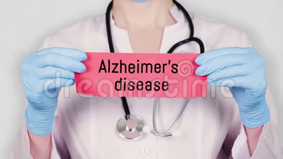 特写双手戴蓝色医用手套手持撕红纸卡上刻有阿尔茨海默病字样医生视频的预览图