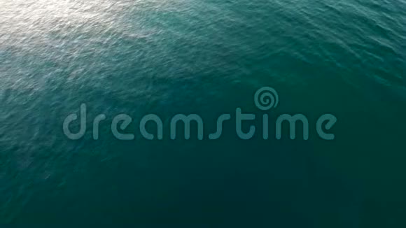 在平静的海洋水面上随着阳光的反射海浪缓慢移动视频的预览图