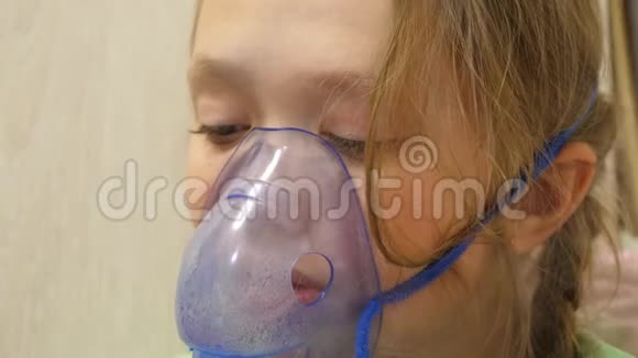 一个生病的女孩用吸入剂通过呼吸药物治疗喉咙特写镜头一个戴面具的孩子吸入视频的预览图
