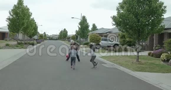 老年妇女和两个年幼的孩子在街上打篮球老妇人在传球前运球和弹球视频的预览图
