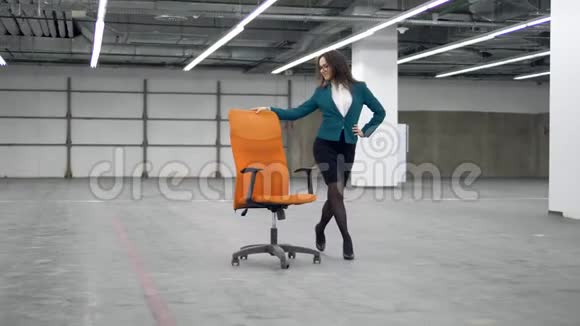一位穿裙子的女士正带着一把摇椅愉快地沿着大厅走视频的预览图