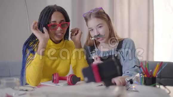积极的女性青少年朋友在自拍相机交谈视频博客戴着红色眼镜的非裔美国女孩视频的预览图