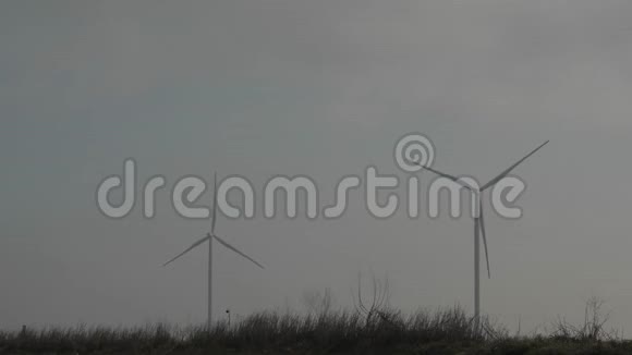 两个旋转风力发电机对抗灰色天空风的力量清洁和可再生能源解决方案风力涡轮机视频的预览图