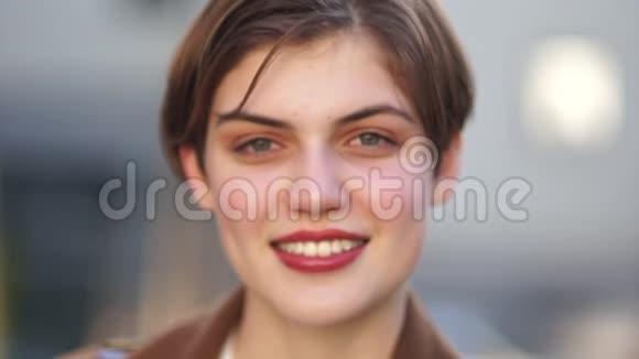 一个美丽的微笑女孩的短裙嘴唇上涂着红色的唇膏快乐的女人视频的预览图