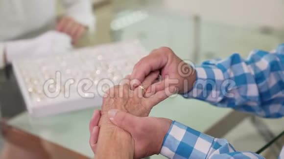 老人帮助他可爱的女人尝试金戒指视频的预览图