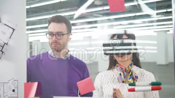 VR眼镜的女建筑师和她的男同事正在谈话视频的预览图