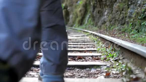 年轻的男性背包客独自乘坐火车轨道后景视频的预览图