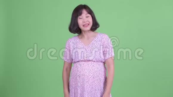 快乐的亚洲孕妇展示了一些东西视频的预览图