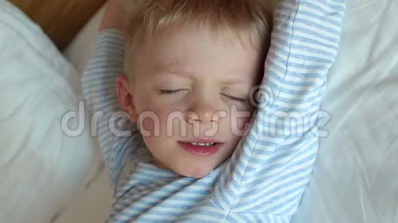 小可爱困男孩5岁早上在床上醒来特写镜头视频的预览图