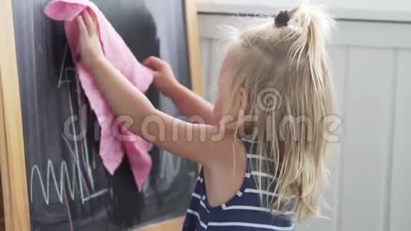 穿条纹连衣裙的婴儿正在从木板上抹去照片视频的预览图