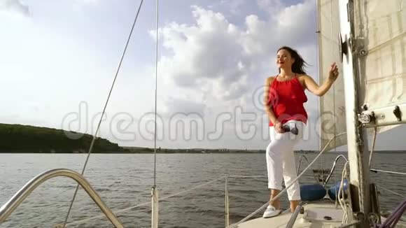 穿着红白衣服的微笑女人在帆船上放松视频的预览图