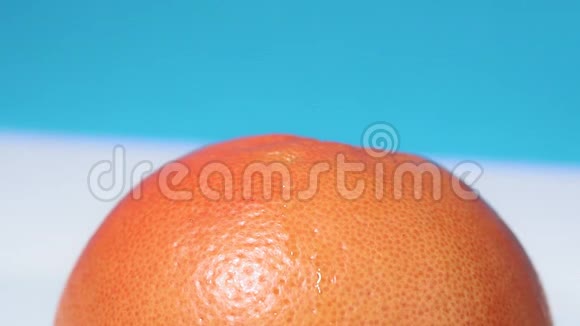 在蓝色背景下注射葡萄柚水果和注射器化学转基因食品选择性聚焦视频的预览图