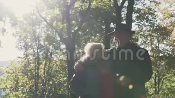 老夫妇在公园里阳光下散步视频的预览图