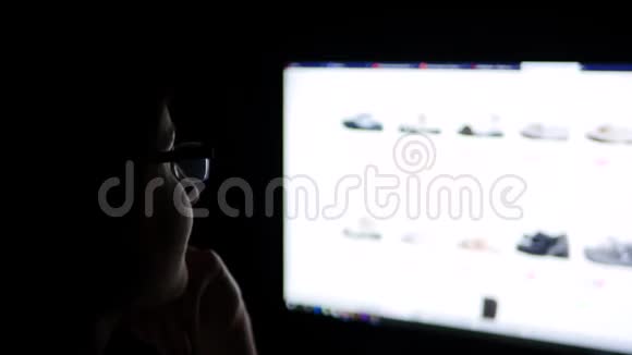 晚上一个戴着眼镜的黑发女人在家里用电脑浏览互联网网站在家里上网买鞋子视频的预览图