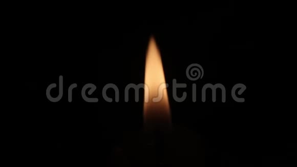 一支蜡烛的橙色小火焰在黑暗中燃烧纯黑色背景丧葬或精神插图视频的预览图