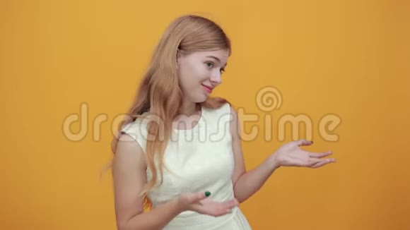 失望的金发女郎张开双手侧过橙色的墙视频的预览图