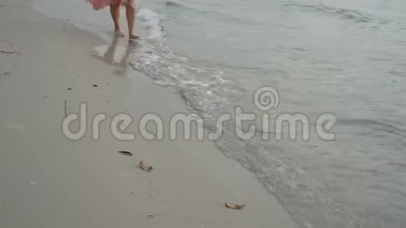 在沙滩上年轻女子赤着脚走在沙滩上视频的预览图