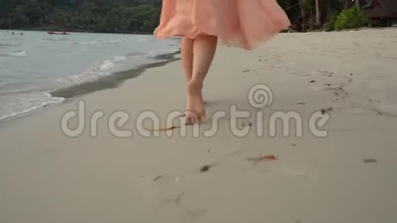 在沙滩上年轻女子赤着脚走在沙滩上视频的预览图